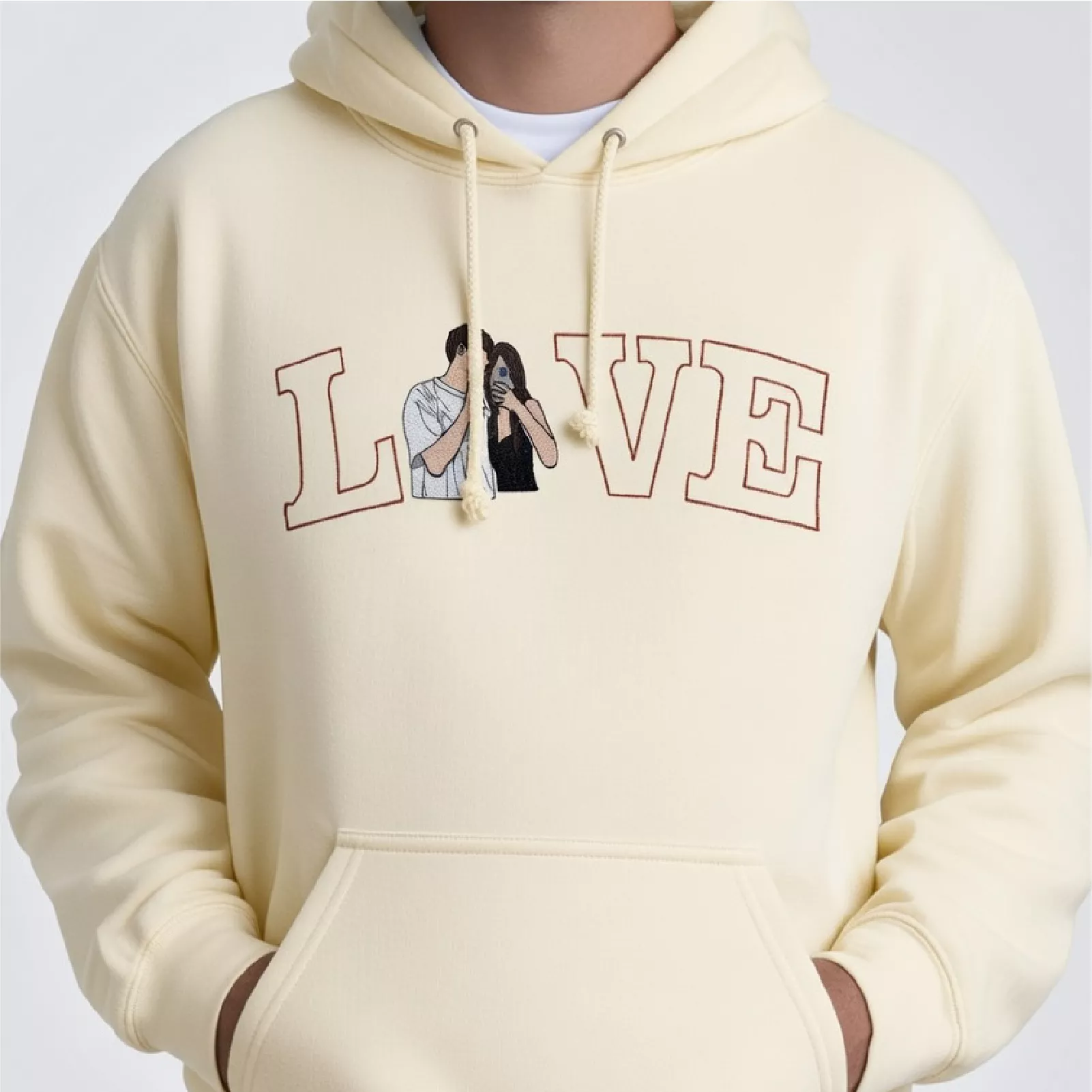 Custom embroidered hoodie with romantic couple portrait and "LOVE" text in light yellow fabric