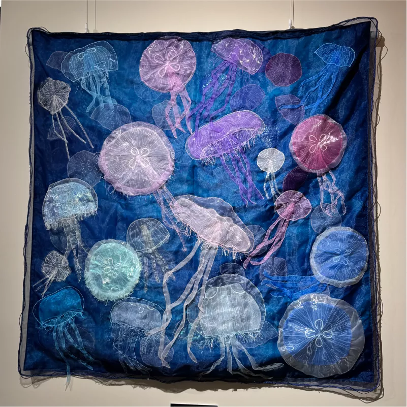 深藍色布料上的水母刺繡作品，展示學生運用不同線材進行藝術創作的成果